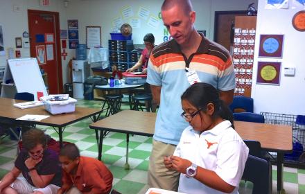 Teacher observing young student.